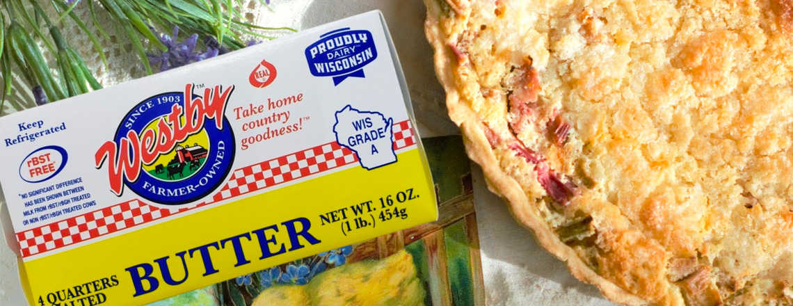 Close up of a package of Westby Cooperative Creamery butter and a strawberry rhubarb pie.