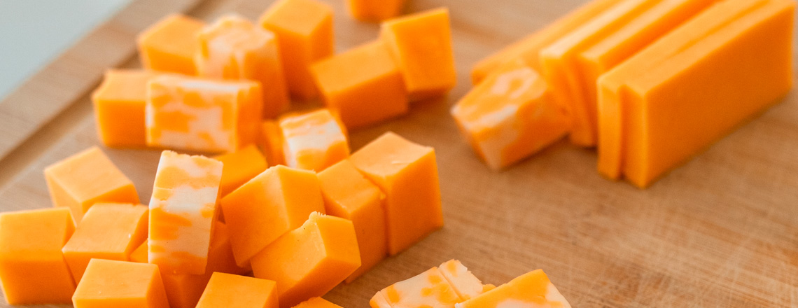 Cubes and slices of colby jack and cheddar cheeses.