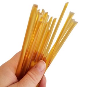 Hand holding a bundle of honey sticks.